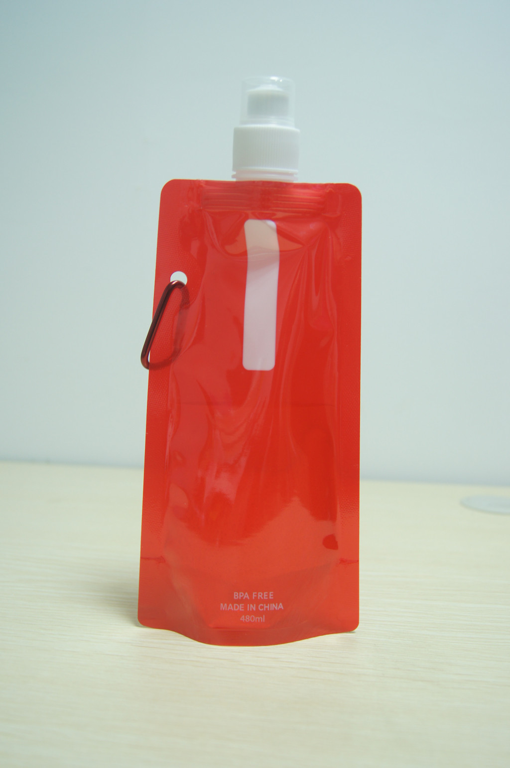 En plastique rouges lumineux tiennent la poche avec l'emballage de boissons de crochet en métal/tiennent la poche pour le jus/aliment pour bébé tiennent la poche
